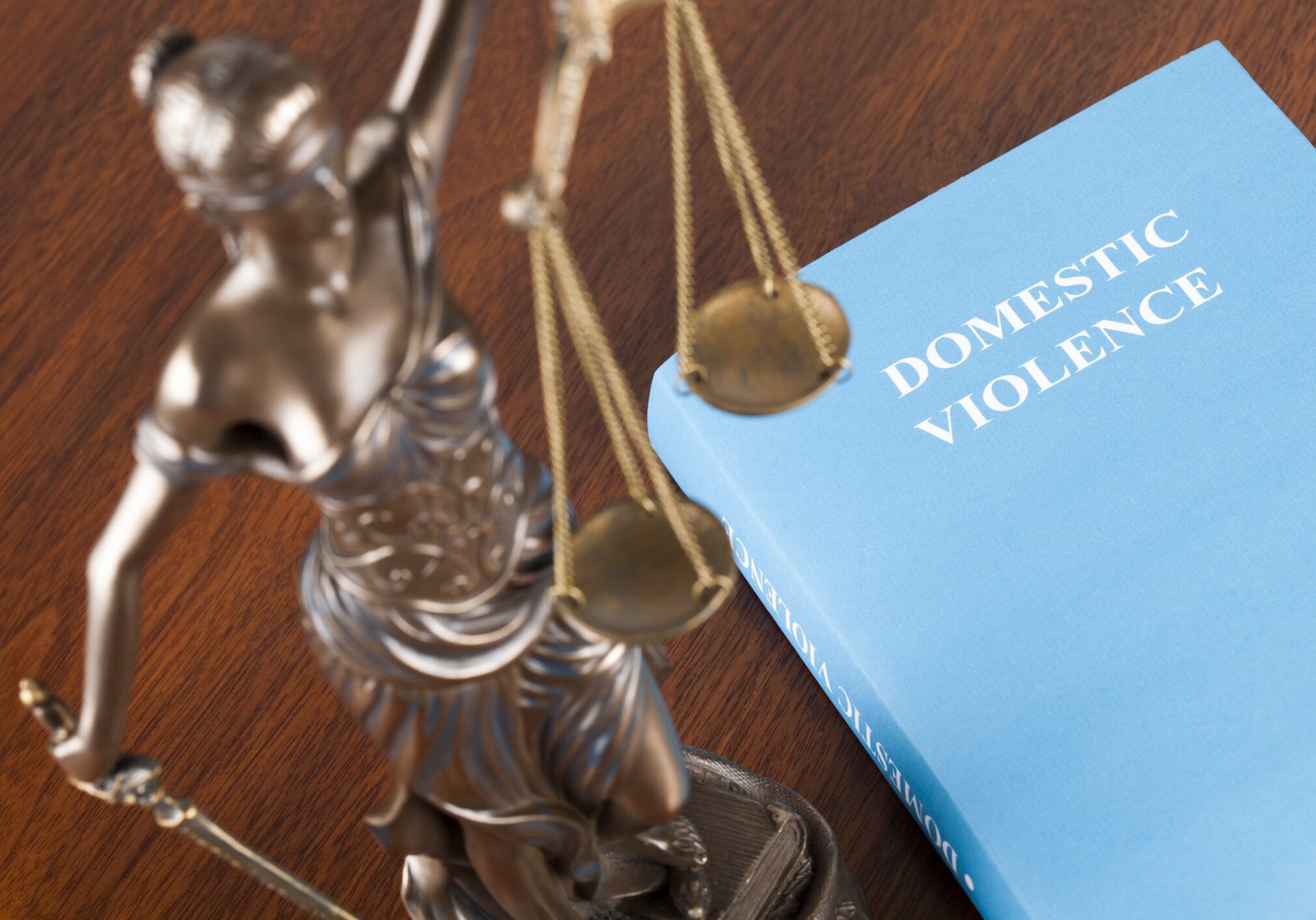 Scales of justice beside a domestic violence booklet.